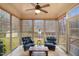 A cozy sunroom is brightly lit and includes a ceiling fan, tile floor and windows overlooking the backyard at 7100 Winter Pond Way, Fuquay Varina, NC 27526