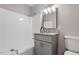 Bright bathroom with a combined shower and tub and a gray vanity with granite countertop at 838 Waring St, Durham, NC 27704
