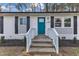 Charming brick home with a bright blue front door and well-maintained landscaping at 838 Waring St, Durham, NC 27704