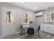 Eat-in kitchen features white cabinetry, stainless steel appliances, and a glass top dining table at 838 Waring St, Durham, NC 27704