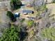Brick home with outbuildings and a long driveway is nestled among mature trees at 8604 N Roxboro St, Bahama, NC 27503