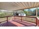 Relax on this covered back porch with wooden floors and railing overlooking a spacious backyard and additional outbuilding at 8604 N Roxboro St, Bahama, NC 27503