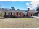 A cozy brick home with classic white-trimmed windows and tidy landscaping on a sunny day at 8604 N Roxboro St, Bahama, NC 27503