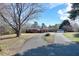 Charming brick home with a long circular driveway, an attached carport, and a separate two-car garage with a connecting driveway at 8604 N Roxboro St, Bahama, NC 27503