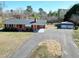 Charming brick home featuring a well-maintained lawn, a long driveway and a separate carport with metal awning at 8604 N Roxboro St, Bahama, NC 27503