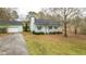 Charming single-story home featuring a covered front porch, green exterior, and detached garage at 879 Cheves Rd, Zebulon, NC 27597