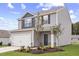 Charming two-story home with gray siding, stone accents, and a two-car garage in a well-kept yard at 909 Rhino Bnd, Oxford, NC 27565