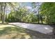 Backyard features a concrete basketball court with a hoop, surrounded by mature trees at 938 Hargrove St, Henderson, NC 27536