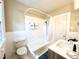 Bathroom with tub, shower, toilet, and vanity, featuring white tile and fixtures, plus a neutral paint palette at 938 Hargrove St, Henderson, NC 27536