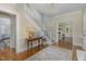 Grand foyer with a view of the living room, hardwood floors, and a staircase with white railings at 938 Hargrove St, Henderson, NC 27536