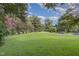 Expansive front yard view with mature trees and a long driveway leading to the home at 938 Hargrove St, Henderson, NC 27536