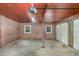 This garage features brick walls, two windows for natural light, an overhead door and a red painted ceiling at 938 Hargrove St, Henderson, NC 27536