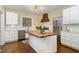 Well-lit kitchen with white cabinets, stainless steel appliances, and a central kitchen island with wood countertop at 938 Hargrove St, Henderson, NC 27536