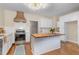 Bright kitchen featuring white cabinets, stainless steel appliances, and a stylish wooden kitchen island at 938 Hargrove St, Henderson, NC 27536