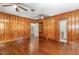 This living room offers wood paneling, hardwood floors, ceiling fan and a built-in shelf at 938 Hargrove St, Henderson, NC 27536