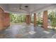 The covered patio features brick pillars, fan and grey tile flooring with outdoor views at 938 Hargrove St, Henderson, NC 27536