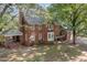 Rear exterior view of a brick home with a covered porch and beautiful backyard at 938 Hargrove St, Henderson, NC 27536