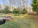A fenced-in backyard featuring trees and an ornamental garden at 1006 Scotsburg Trl, Hillsborough, NC 27278