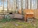 Backyard scene with a rustic bench, potting table and various trees and greenery at 1006 Scotsburg Trl, Hillsborough, NC 27278