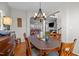 Traditional dining room featuring hardwood floors, with chandelier and furniture, adjacent to a living area with fireplace at 1006 Scotsburg Trl, Hillsborough, NC 27278