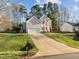 Inviting two-story home with an attached garage, set on a well-kept lawn with mature trees, showcasing suburban charm at 1006 Scotsburg Trl, Hillsborough, NC 27278