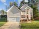 Charming two-story home featuring a well-manicured lawn and an attached two-car garage, creating a welcoming curb appeal at 1006 Scotsburg Trl, Hillsborough, NC 27278