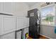 Convenient laundry room with stacked washer and dryer, built-in cabinets, and natural light at 1006 Scotsburg Trl, Hillsborough, NC 27278