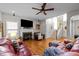 Bright living room features a fireplace, flat screen television, ceiling fan and an open staircase at 1006 Scotsburg Trl, Hillsborough, NC 27278