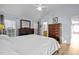 Bright main bedroom featuring a ceiling fan, wood floors, and ensuite bathroom access at 1006 Scotsburg Trl, Hillsborough, NC 27278