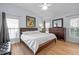 Spacious main bedroom with a wooden bed frame, two windows, and a wooden dresser at 1006 Scotsburg Trl, Hillsborough, NC 27278