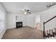 Bright living room showcasing a cozy fireplace, ceiling fan and staircase leading to the upper level at 101 Wimbledon Ct, Clayton, NC 27520