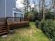 Backyard featuring a wooden deck and a grassy area bordered by lush greenery at 103 Glenstone Ln, Cary, NC 27518