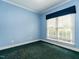 Serene bedroom with blue walls, green carpet, and a window for natural light at 103 Glenstone Ln, Cary, NC 27518