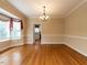 Elegant dining room with hardwood floors, a bay window, and chandelier lighting at 103 Glenstone Ln, Cary, NC 27518