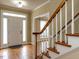 Spacious foyer with hardwood floors, staircase, and natural light from the front door at 103 Glenstone Ln, Cary, NC 27518