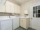 Functional laundry room with washer, dryer, utility sink, and ample cabinet storage at 103 Glenstone Ln, Cary, NC 27518