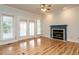 Cozy living room with a fireplace, hardwood floors, and access to the outdoor patio at 103 Glenstone Ln, Cary, NC 27518