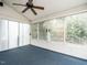 Bright sunroom featuring large windows, sliding doors, a ceiling fan, and blue carpeted flooring at 103 Glenstone Ln, Cary, NC 27518