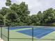 A view of fenced tennis courts surrounded by mature trees at 103 Glenstone Ln, Cary, NC 27518