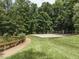 A sand volleyball court surrounded by trees, with a grassy path leading up to the court at 103 Glenstone Ln, Cary, NC 27518