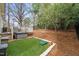 View of backyard showing manicured lawn, mature trees, and fenced perimeter at 104 Chris Ct, Cary, NC 27511