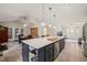 Open-concept view of the kitchen with island and seating that flows to dining and living rooms at 104 Chris Ct, Cary, NC 27511