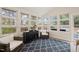 Bright sunroom with many windows, black cabinet, blue rug, and wicker chairs at 104 Chris Ct, Cary, NC 27511