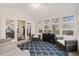 Light-filled sunroom features a blue patterned rug, black cabinet, and comfortable seating at 104 Chris Ct, Cary, NC 27511