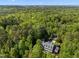 Aerial shot of property surrounded by lush greenery with house, pool, and pool house at 109 Chimeneas Pl, Chapel Hill, NC 27517