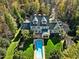 Aerial view of the large home and backyard featuring a pool, lush landscaping, and mature trees at 109 Chimeneas Pl, Chapel Hill, NC 27517