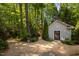 Charming backyard featuring a small building and a stone pathway surrounded by lush greenery at 109 Chimeneas Pl, Chapel Hill, NC 27517