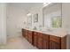 Bright bathroom with double vanity, wood cabinets, and neutral tile flooring at 109 Chimeneas Pl, Chapel Hill, NC 27517