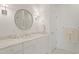Clean white bathroom featuring marble countertop, a circular mirror, and neutral finishes for a timeless look at 109 Chimeneas Pl, Chapel Hill, NC 27517