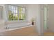 Inviting bathroom featuring a luxurious soaking tub and a serene backyard view at 109 Chimeneas Pl, Chapel Hill, NC 27517